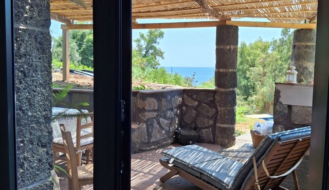 typical Sicilian stone house on the sea surrounded by greenery